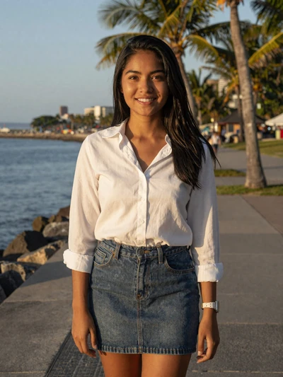 Filipina woman smiling on tropical waterfront promenade at golden hour