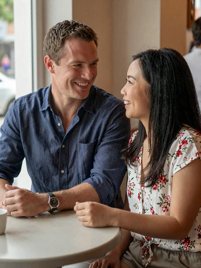 Western man and Asian woman enjoying cross-cultural date at cozy cafe