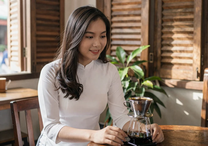 Vietnamese woman enjoying traditional ca phe sua da at a cozy coffee shop in Saigon