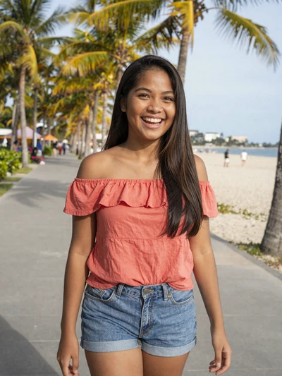 Angela, 23, Filipina woman from Davao laughing on beach boardwalk